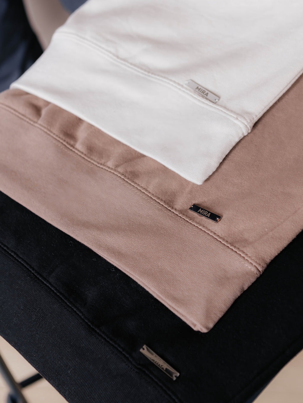 Close-up of oat, latte, and black Mira One Day Crew Necks